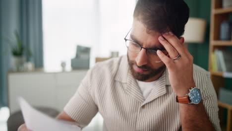stressed man looking at paperwork