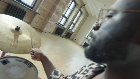 black drummer hitting hi-hat while playing drums