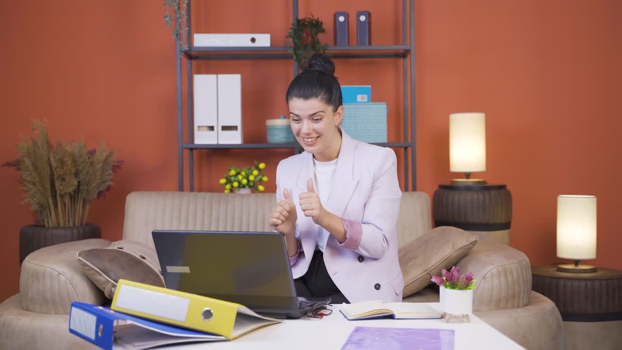 Home office worker young woman applauding what she sees on laptop.