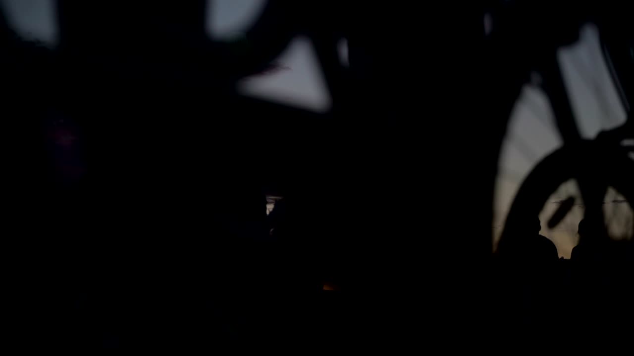 concepto de parque de la ciudad en la noche de verano y estilo de vida saludable. siluetas de personas paseando en el fondo del cielo al atardecer. ciclistas, patinadores y patinadores que pasan. vista de ángulo bajo bucle de lapso de tiempo