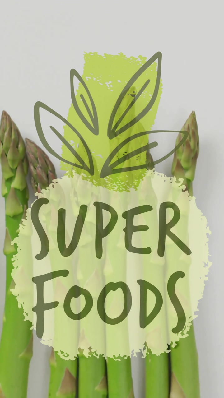 Super foods text animation over fresh asparagus on white background