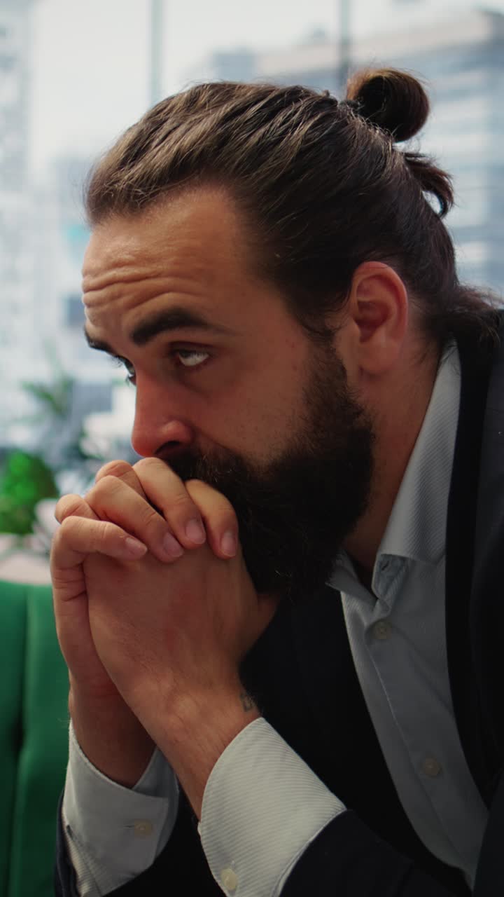 Vertical Video Male corporate leader buries his face in his hands due to frustration