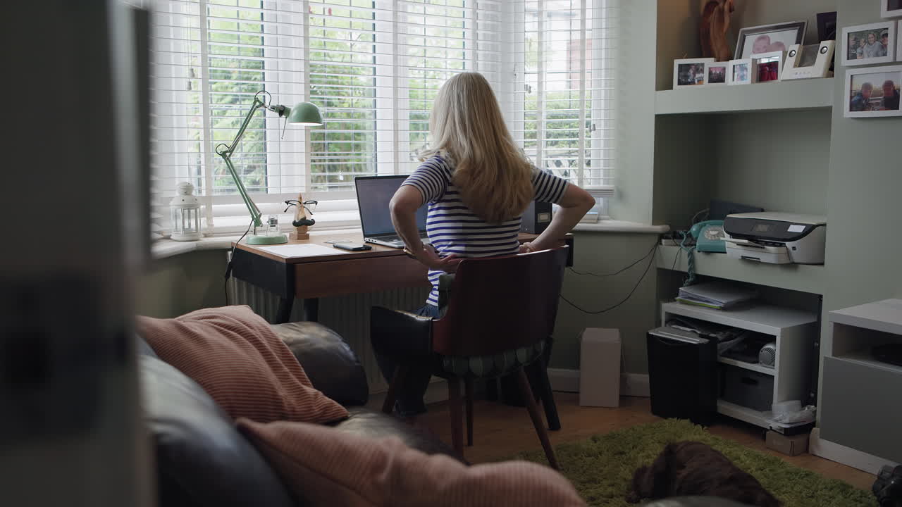Woman working from home in her home office with a dog sleeping on the floor