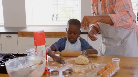 Vorderansicht-Eines-Mittleren-Erwachsenen-Schwarzen-Vaters-Und-Sohnes,-Der-In-Der-Küche-Eines-Komfortablen-Zuhauses-Kekse-Backt,-4K