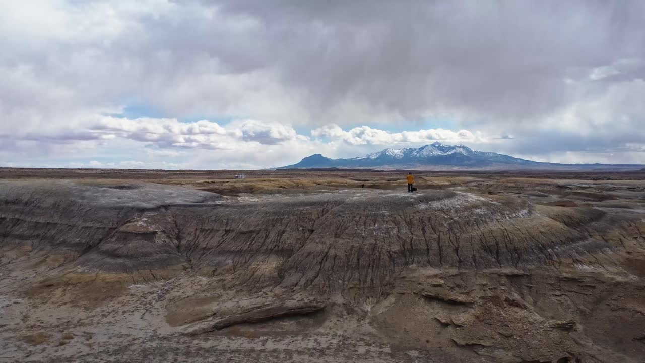 explorador anónimo observando el valle montañoso desde la cima de la colina