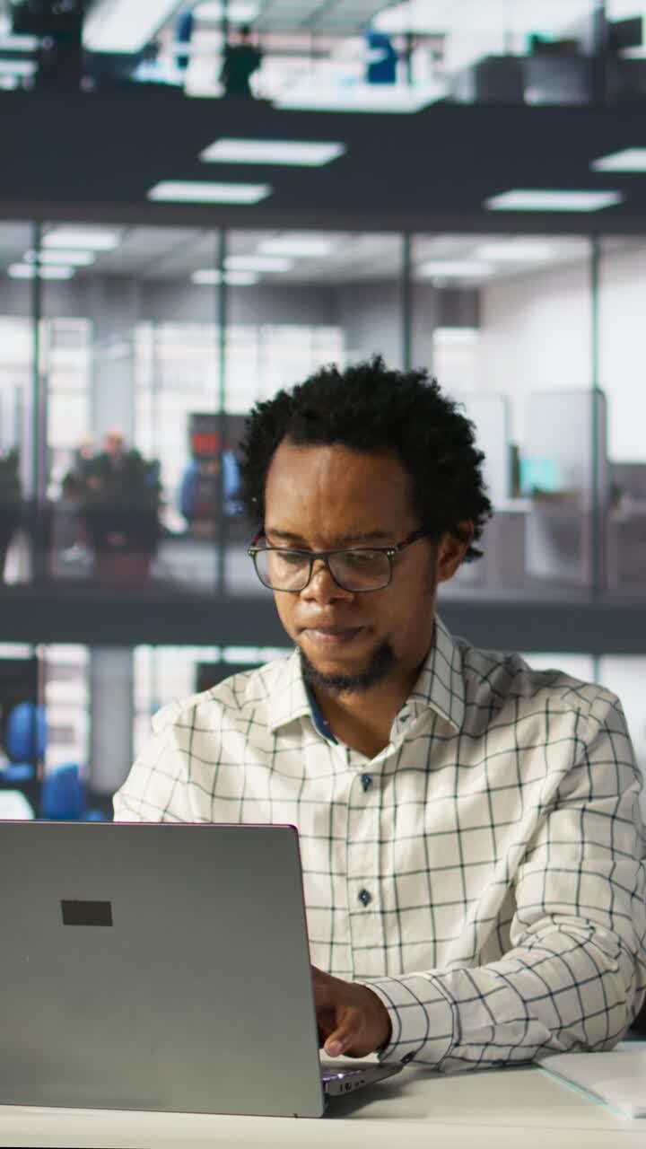 African American Man Working on Laptop and Smiling in Modern Office