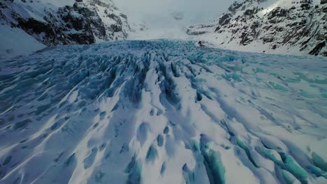 beautiful formation and texture of snow covered the carvasses of kviarjokull glacier outlet in south iceland.  - aerial drone