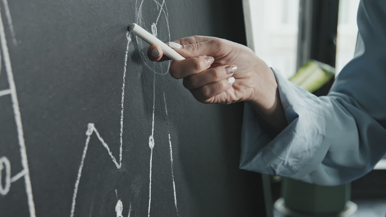 Female Hand Drawing Business Graph on Chalkboard