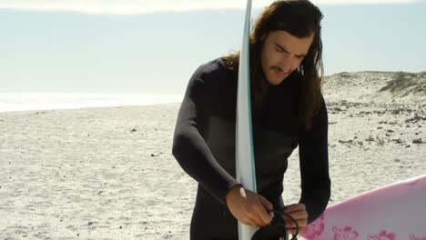 hombre con tabla de surf en la playa 4k