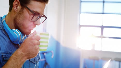 ejecutivo de negocios tomando café mientras usa una computadora portátil