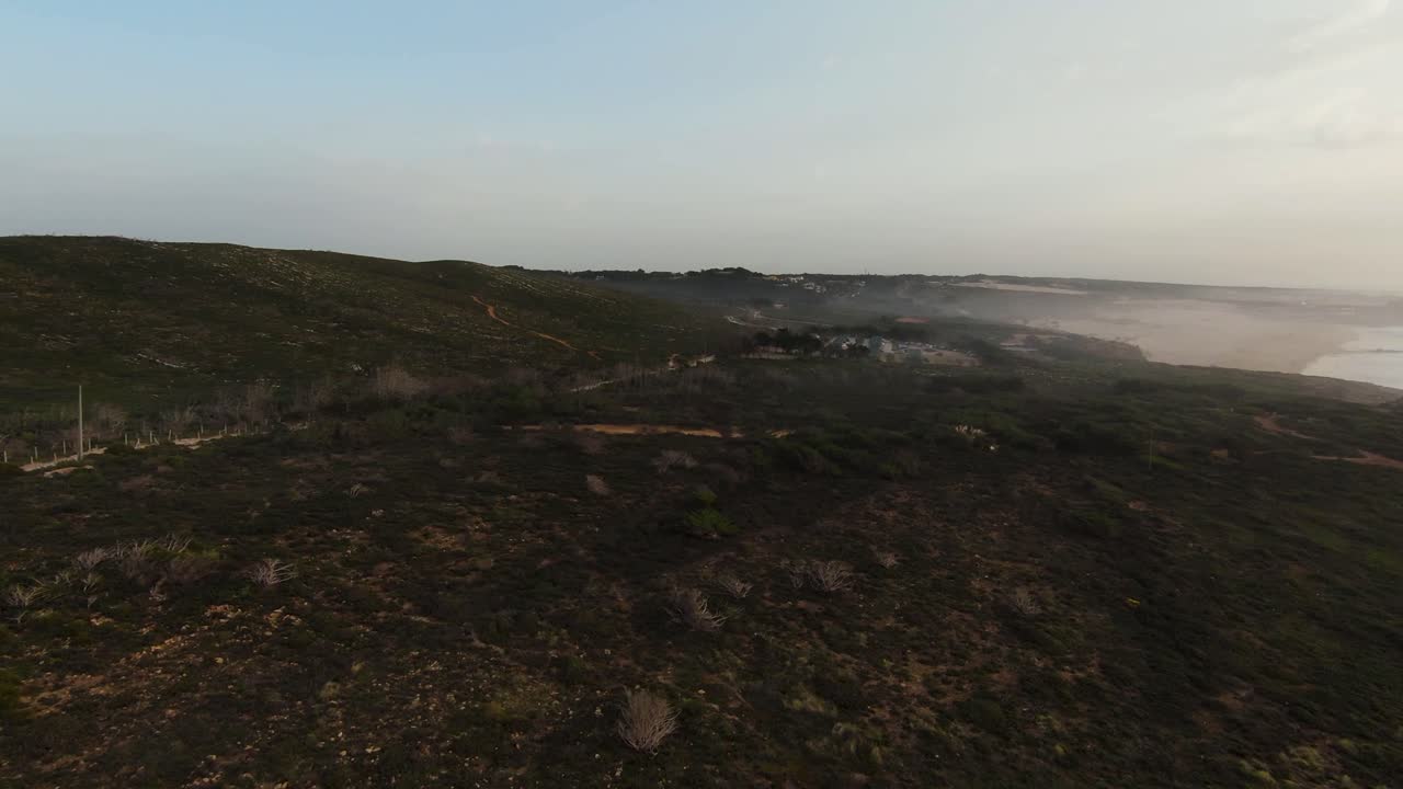 imágenes aéreas de fpv de drones pov abrazando la hermosa montaña rocosa junto al mar en cascais, portugal, con olas rompiendo en el fondo