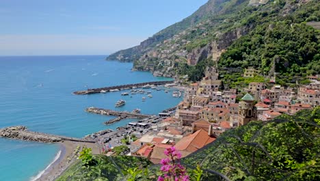 Panoramic-view-of-Amalfi-town,-a-touristic-town-of-the-Amalfi-Coast-with-colorful-flower-in-the-foreground