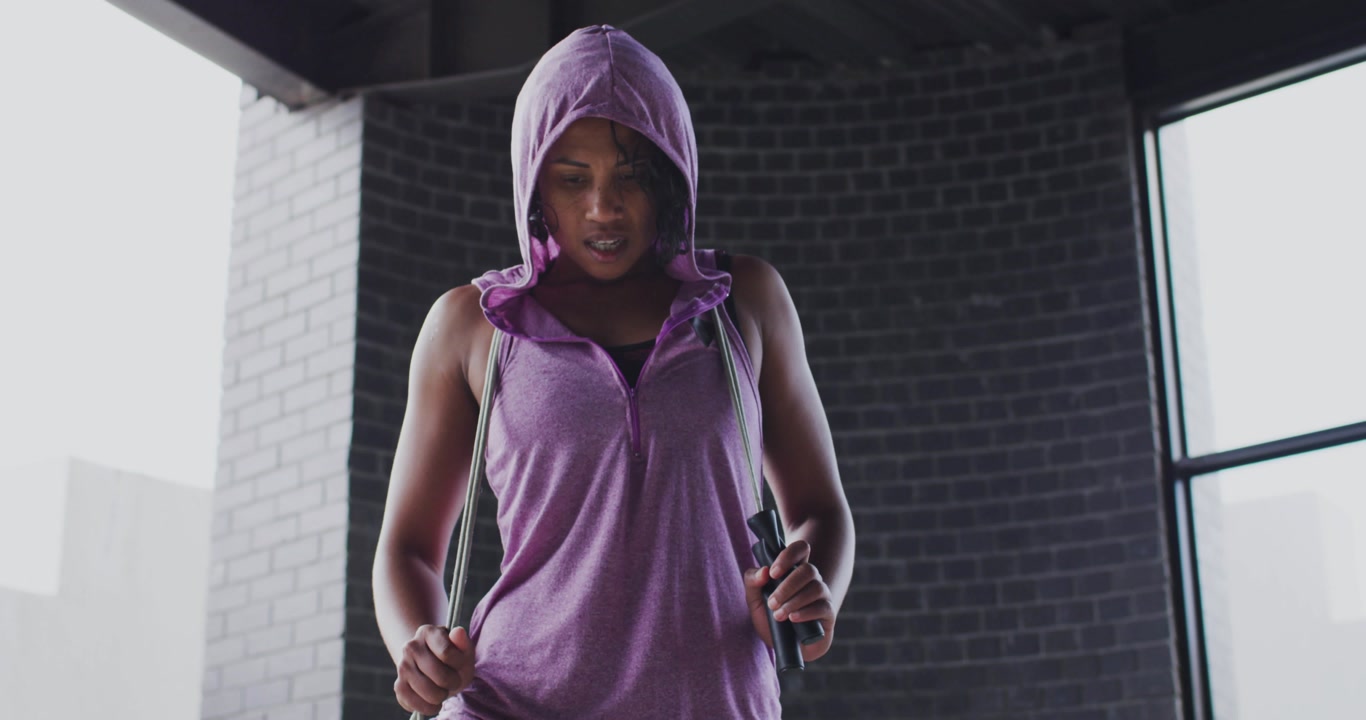 Woman raising rope, starting animated hearts floating,dissolving on chest preparing fitness workout