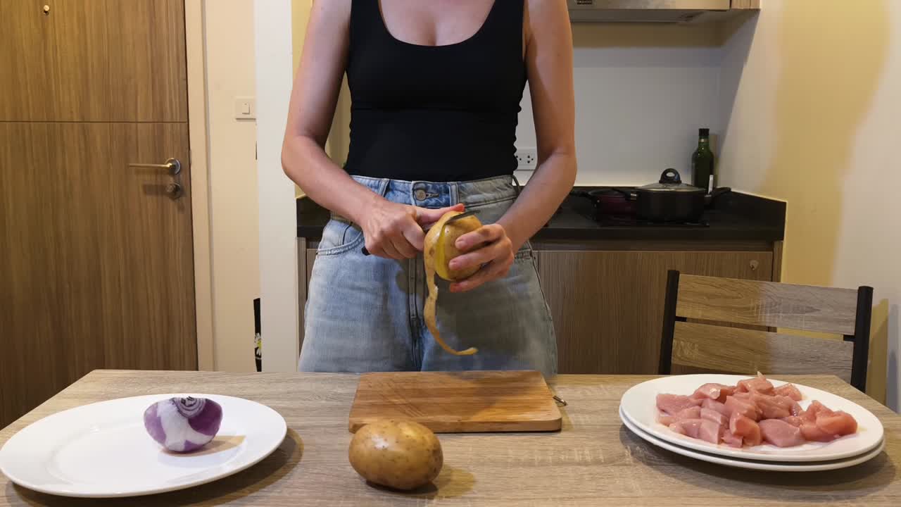 Woman peeling potato for cooking