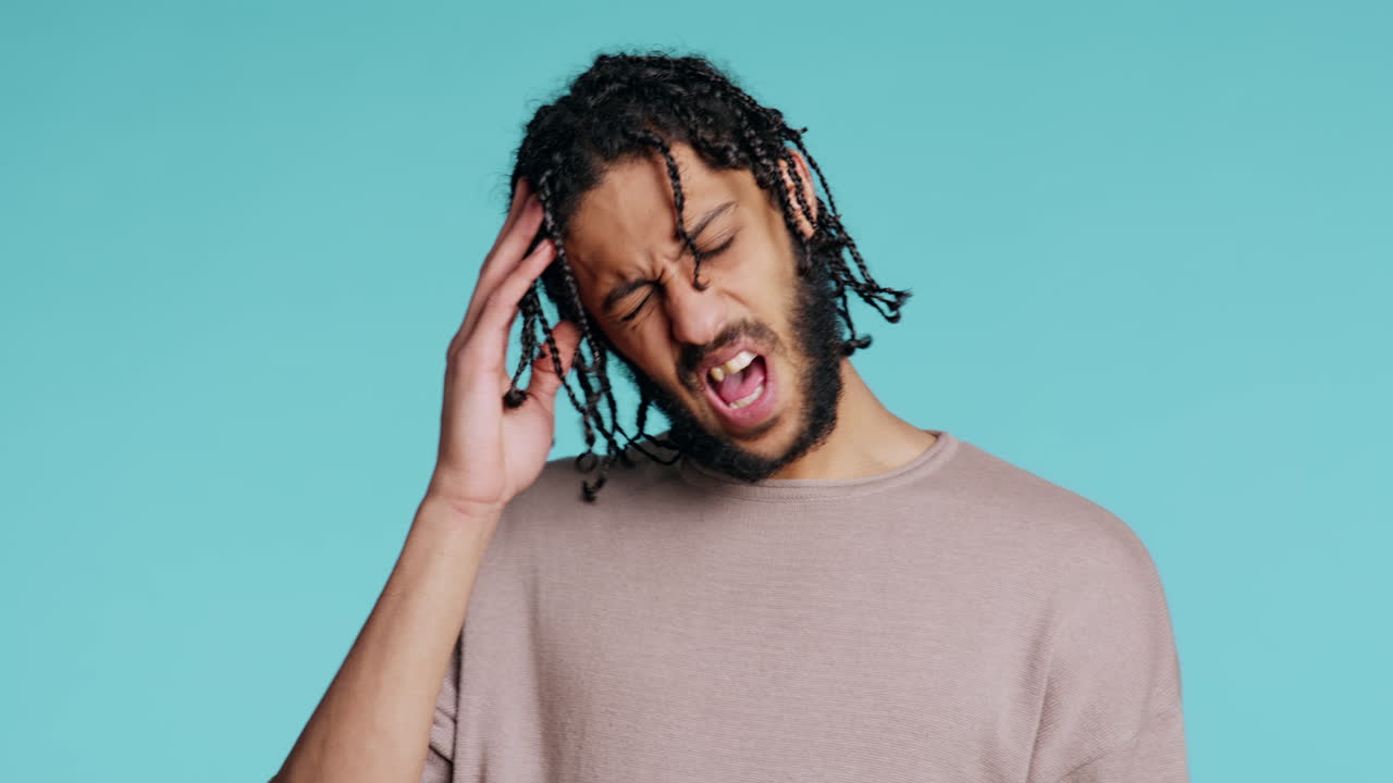 hombre estremecido por el dolor, sufriendo de dolor de cabeza, fondo de estudio