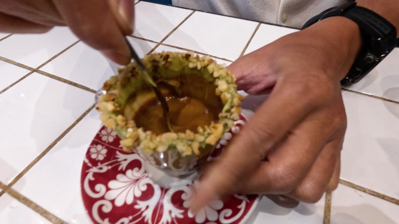 persona mezclando café en una taza con borde de nuez