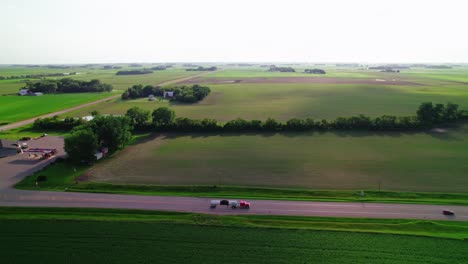 red tanker semi-truck driving in rural minnesota farmland.