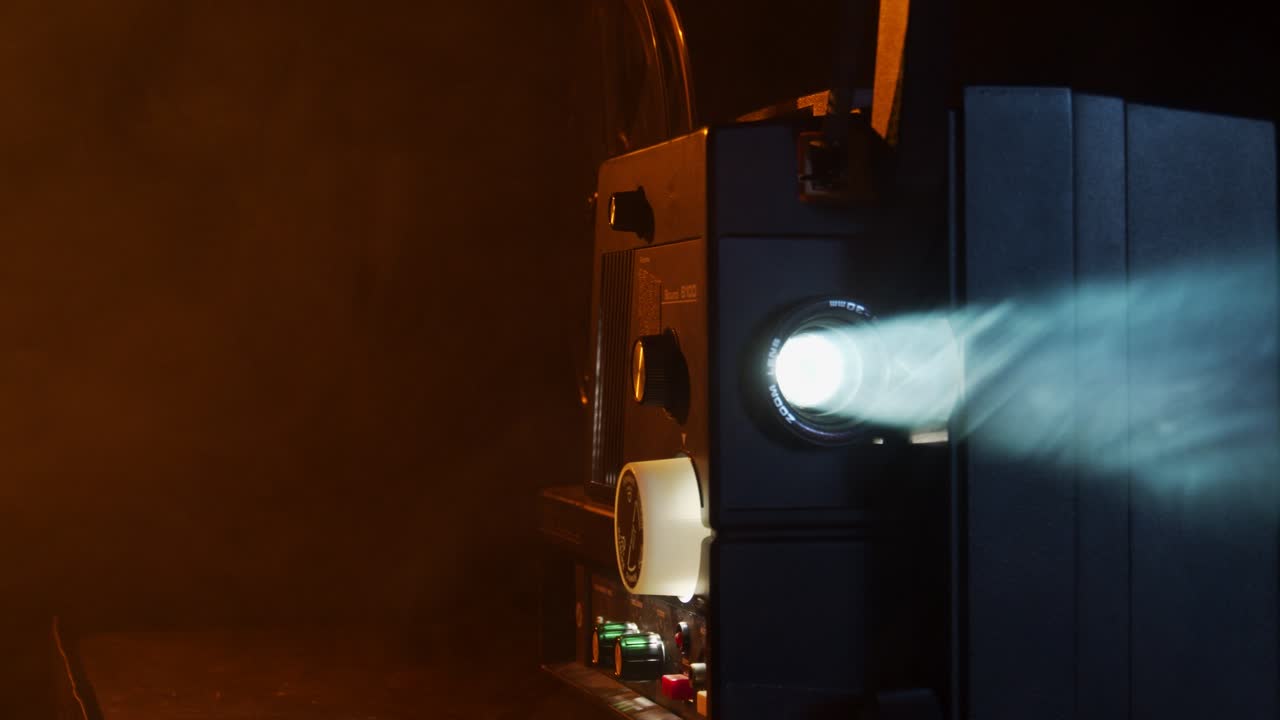 슈퍼 8 영화 프로젝터는 연기가 자욱한 방에서 오래된 홈 무비를 보여줍니다.