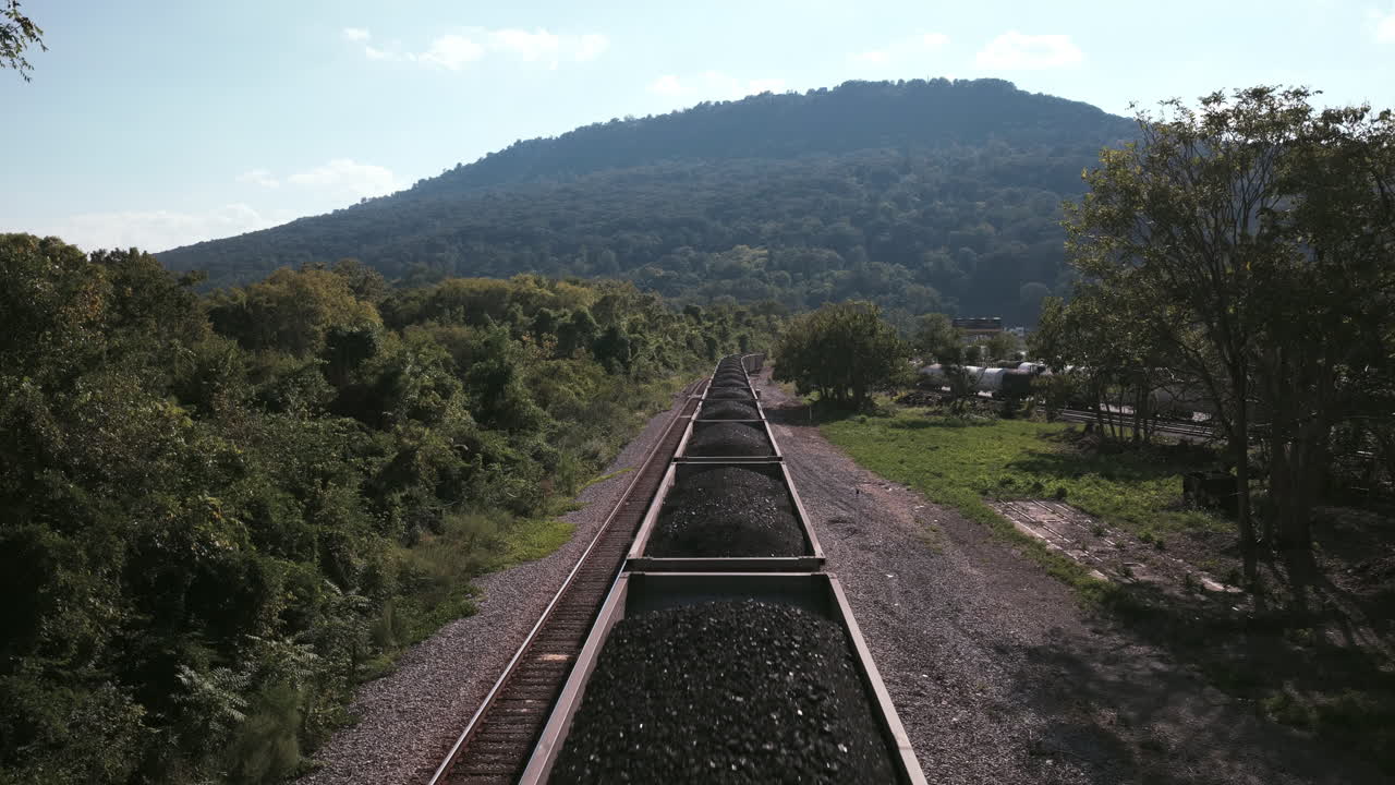 Aerial shot of a long train hauling coal through the Chattanooga area, with Lookout Mountain in the distance