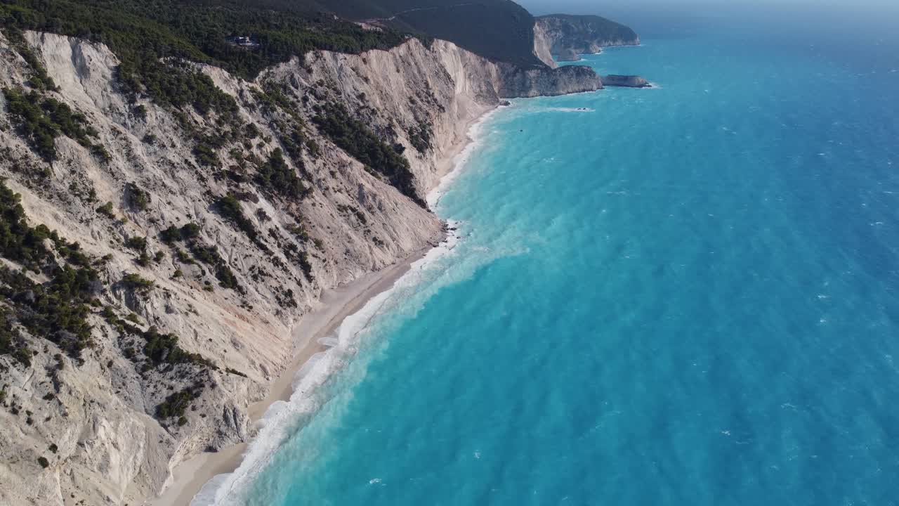 Pobřeží pláže Egremni na Jónském ostrově Lefkada v Řecku, letecký pohled odhaluje horizont a hory.