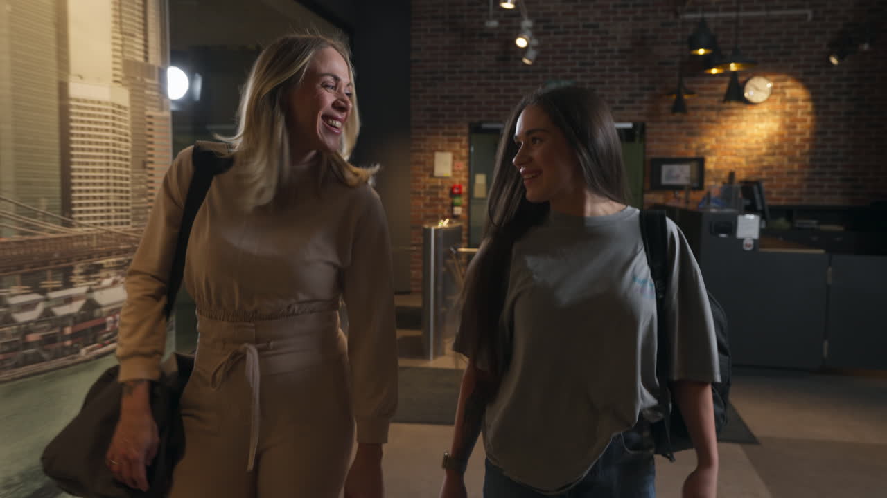 Two beautiful friends coming out of the gym training smiling