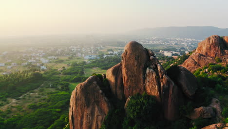 Sunrise over a city nestled beside rugged rock formations