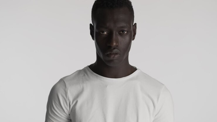 Hombre afroamericano serio sobre fondo gris.