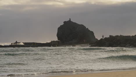 People-Taking-Pictures-Of-The-Roaring-Sea-In-Currumbin-Rock---Sunset-In-Gold-Coast,-Australia---wide-shot