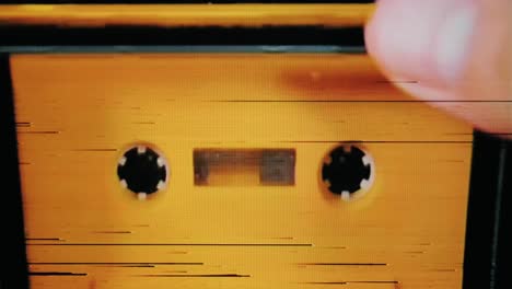 real tv capture: putting a yellow cassette tape into a deck and playing it