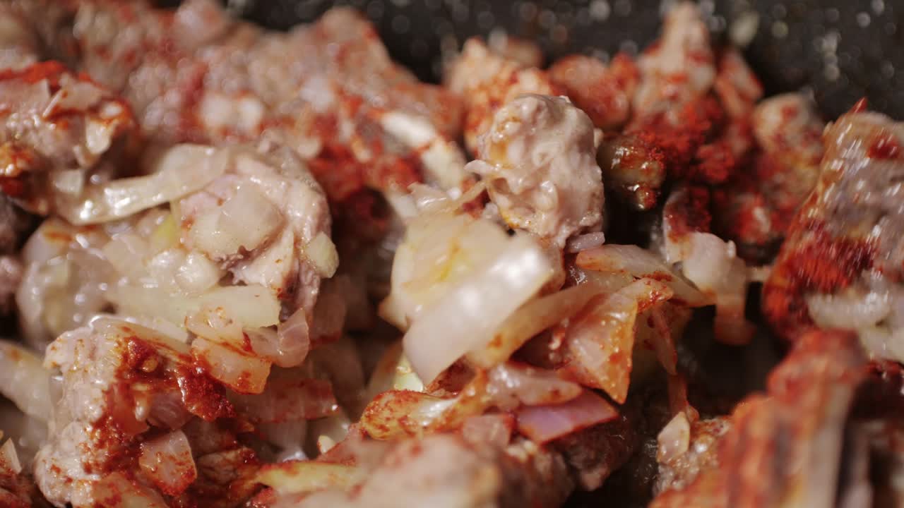 Chicken or pork stew with red and green pepper onion, and spices cooking in a frying pan. Traditional mexican cuisine, tacos preparation, ragout.