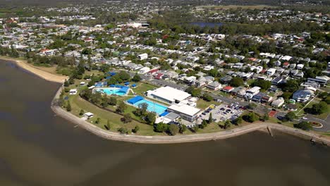 Aerial-view-of-Sandgate-pool-and-Brighton-waterfront-on-a-sunny-day,-Brisbane,-Queensland,-Australia