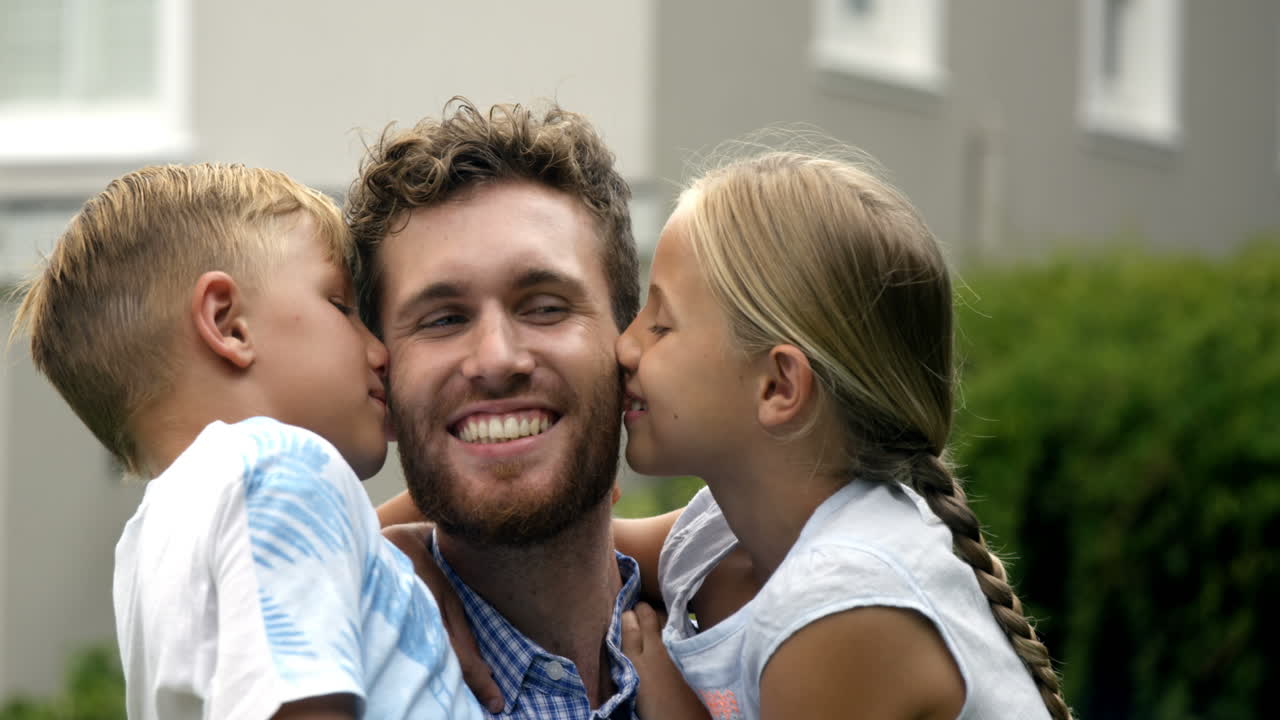 Bambini felici che baciano il loro papà