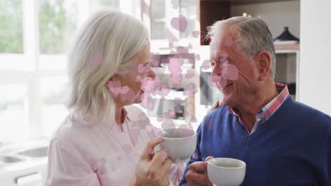 Animación-De-Iconos-De-Corazones-Sobre-Una-Feliz-Pareja-Caucásica-Mayor-Bebiendo-Té