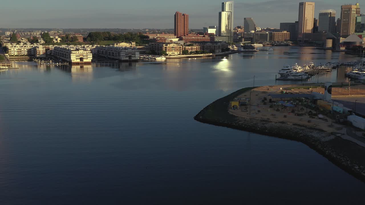 Aerial fly towards the Inner Harbor of Baltimore Maryland at golden hour sunrise
