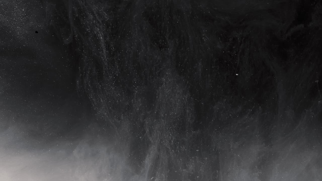 White tiny particles rising in grey smoke