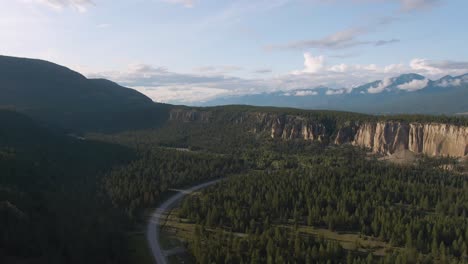 aerial panoramic view of a scenic highway in the valley surrounded by canadian mountain landscape