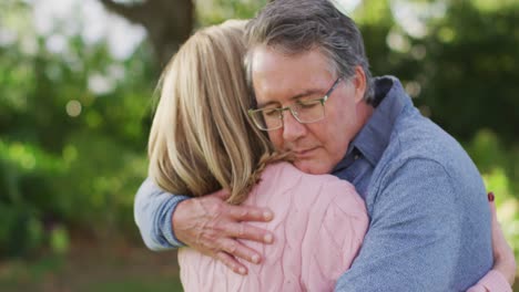 video of happy caucasian senior husband and wife hugging in garden