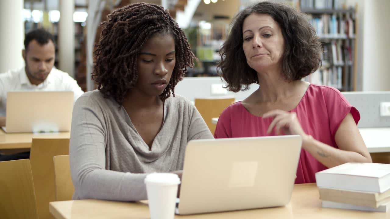 mujeres pensativas discutiendo un nuevo proyecto en la biblioteca