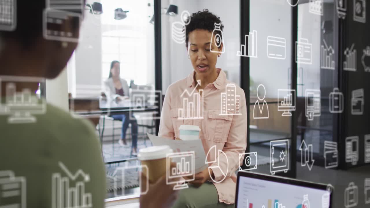 Animation of business icons over diverse businesswomen discussing work