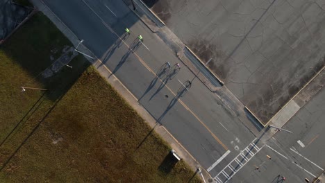 Drone-aerial-rotation-of-bicycle-riders-on-city-street