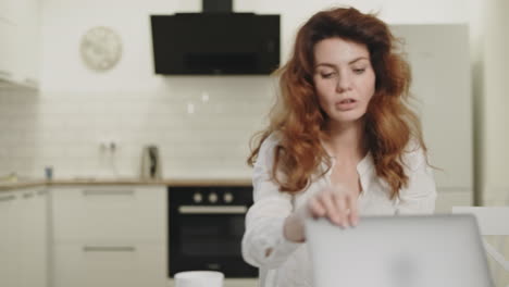 Serious-business-woman-closing-computer-at-remote-workplace.