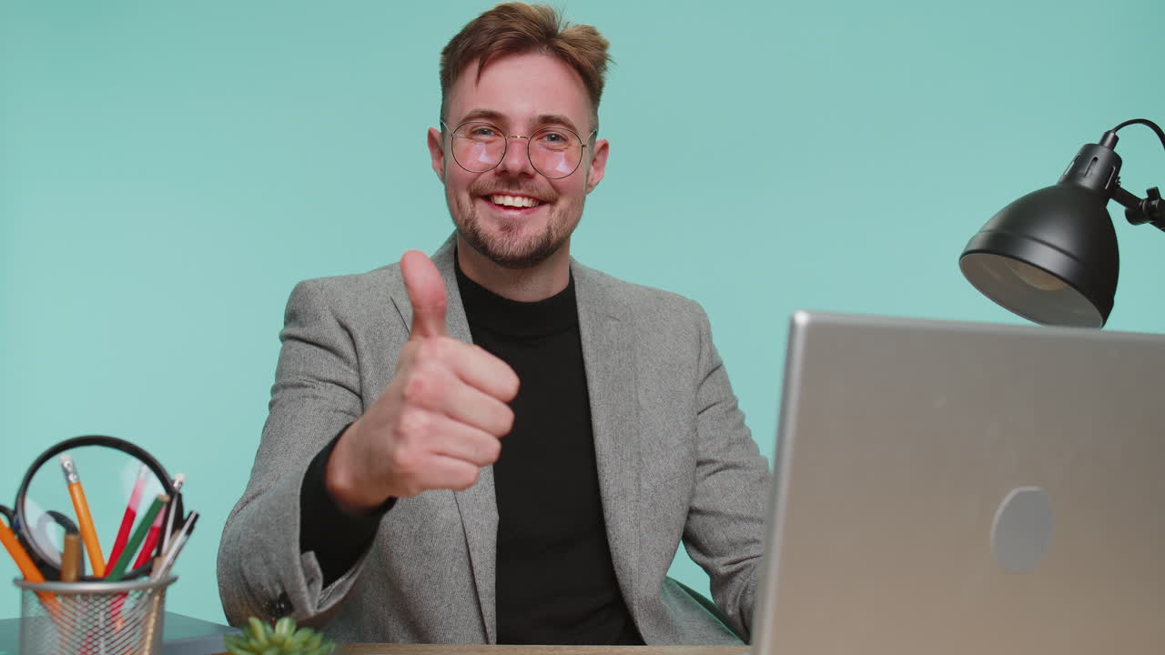 Happy business man raises thumbs up agrees gives positive reply recommends advertisement likes good