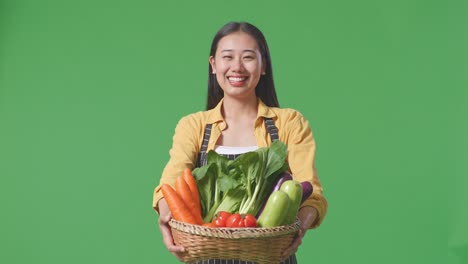 woman holding a basket of fresh vegetables