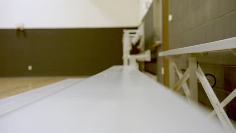 tracking in along empty wooden bleachers on basketball gymnasium, selective focus