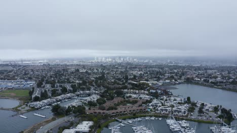 Una-Gran-Ciudad-En-El-Fondo-Del-Puerto-Deportivo-Y-Los-Veleros