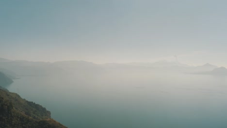 Beautiful-drone-aerial-panoramic-shot-of-lake-Atitlan-during-a-cloudy-morning-in-Guatemala