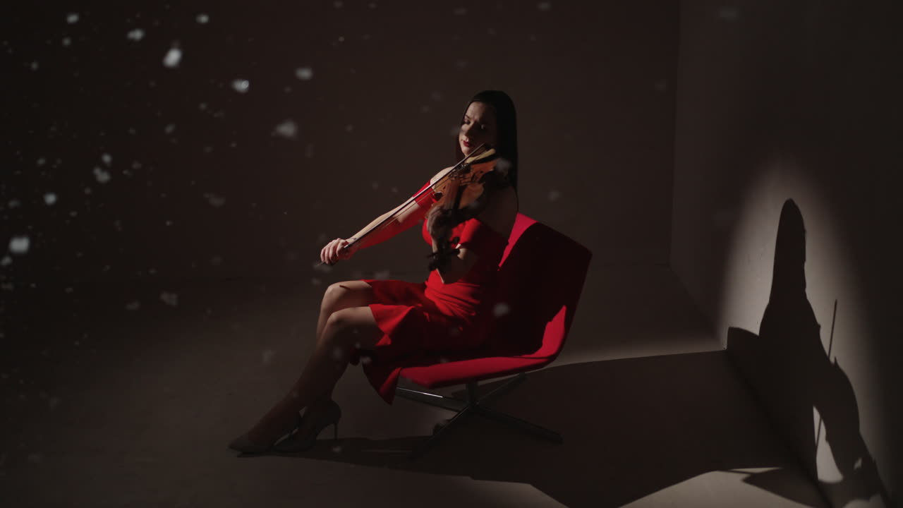 mujer tocando el violín en vestido rojo