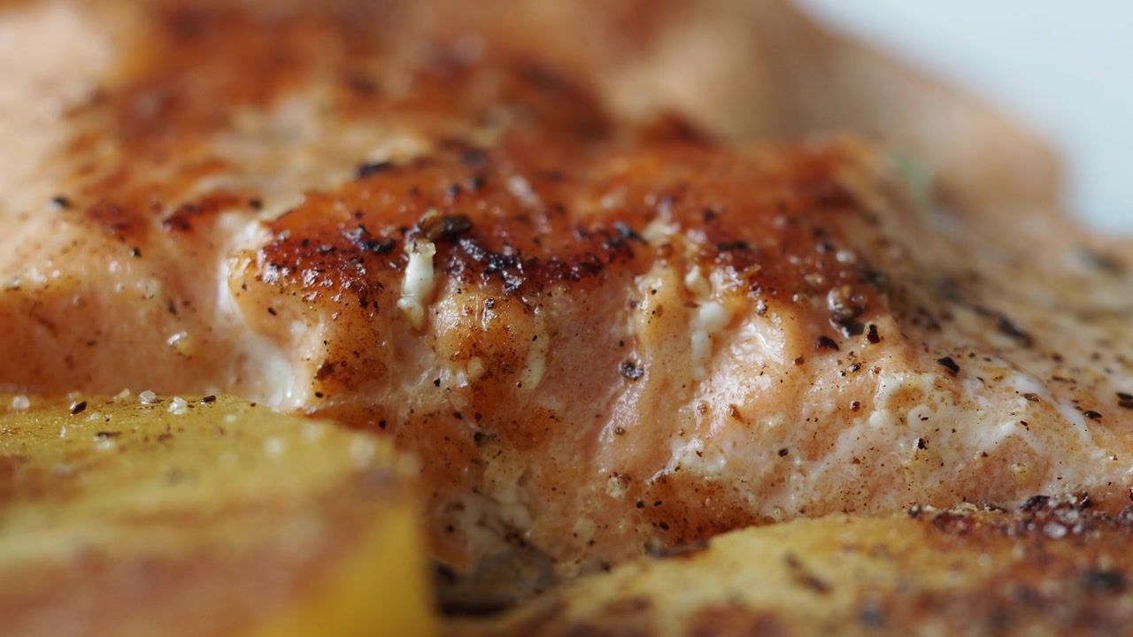 Primo piano di filetto di salmone scottato in padella con condimento