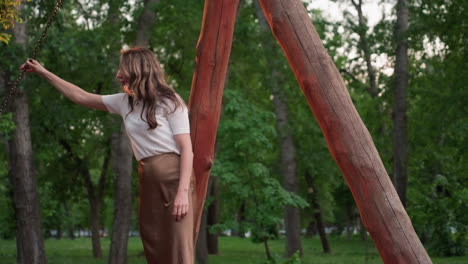 summer children swinging high in leafy park while parents gently support swing chains under warm evening light capturing joyful laughter and playful family moment outdoors smiling together