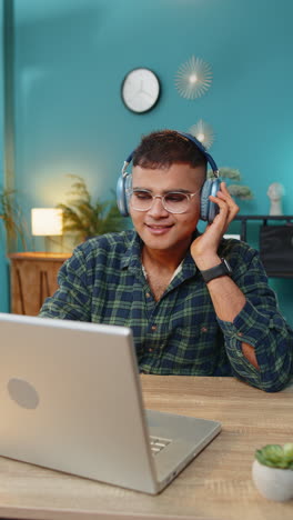 business man listening music through wireless headphones relaxing taking a break laptop on table